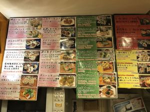Green signs showing vegan rolls at Sushi Roll Double Quotation IKI in Osaka