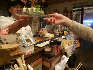 Serve food at Sushi Roll Double Quotation IKI in Osaka