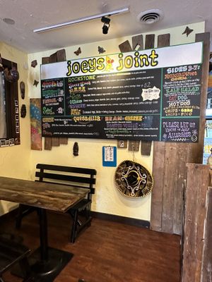 Menu board with seating   at Joey's Joint in Eastham