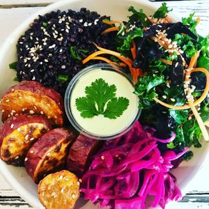 Forbidden rice bowl with sweet potato coins, kale and carrot slaw, pickled red cabbage and cashew cilantro lime cream.  at Cook To Be Well in Knoxville