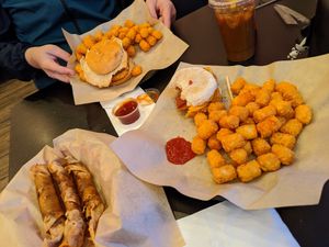 Top-monster fried egg burger with tater tots, iced coffee
Left bottom- impossible Lumpia
Right bottom- breakfast Sammy with bacon and tater tots at Cafe No Fur - Cloud Kitchen in Las Vegas