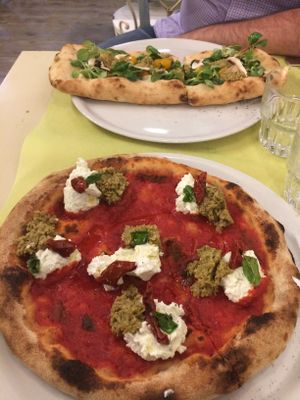 At top - pizza with ricotta-stuffed crust, tomatoes, mushrooms, and herbs. At bottom - pizza with ricotta, chipped olives, and sun-dried tomatoes. The top pizza is pretty big too, this photo's perspective makes it look smaller than it really is at La Pepiniere in Florence