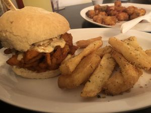 Hot chick sandwich with half the tater tots with black eyed pea salsa in the background.  at Vegelicious in Nashville
