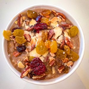 Ancient Grains Porridge -  
GF and Plant-based, lightly maple syrup sweetened. Warm, comforting, and absolutely delicious. Topped with toasted almonds, dried cranberries, raisins. at Aharon Coffee in Beverly Hills