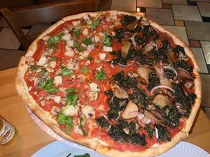 Half and half vegan pizza. Carmelized peaches, spinach, mushrooms,onions and garlic. Also potatoe,tomatoes,garlic, walnuts and cilantro    at Zia Gourmet Pizza in San Diego