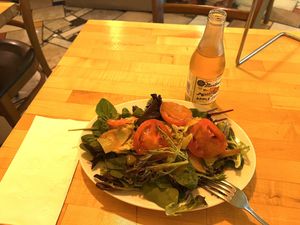 Garden salad with peach dressing and slices of peaches 🍑   at Zia Gourmet Pizza in San Diego
