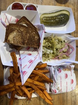 Ruben, burger, with the side combo of pickles, coleslaw, and sweet potato fries   at Beaut Burger in Tucson