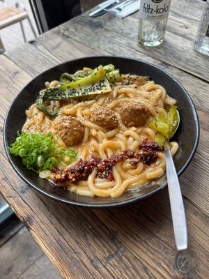 Ben ben noodles = creamy sesame sauce, udon, meatballs, pak soy, crispy chili oil, scallions, pickles at SOIL Vegan Cafe - West in Amsterdam