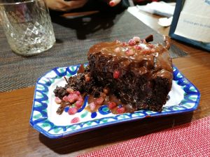 Brownie con chocolate derretido y granada por encima at El Piano in Granada