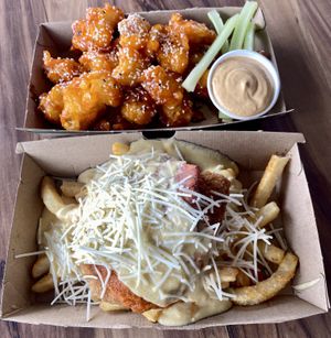 Back: Spicy buffalo cauli wings Front: Chicken parmigiana on chips   at Yavanna in Paddington