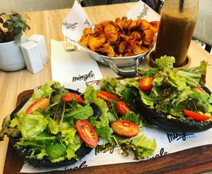 Vegan smashed avocado black brioche bun, sweep potato chips, espresso smoothie  at Mingle Cafe in Larnaca