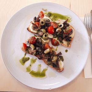 Vegan toast with gluten free bread, the toast as avocado spread, mushrooms, cherry tomatoes, olives and pesto. at Noshi Coffee in Porto
