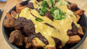 Poutine -- Black bean & mushroom gravy
topped with homemade queso
marinated button mushrooms &
green onio at Lola Rosa - Places des Festivals in Montreal
