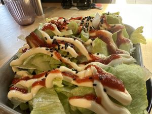 There was shoarma, vegan cheese, and sweet potato fries below the lettuce with mayo and sriracha  at The Black Cockatoo in Almere