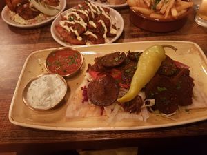 Kebab in foreground mezze stuff in background at Koocha Mezze Bar in Bristol