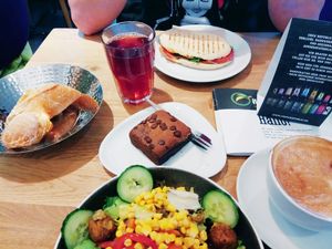 Falafel salad (small) served with bread, cappuccino with soya milk, vegan brownie, vegan blueberry ice tea and a panini with prosciutto at Mischbar in Nuremberg