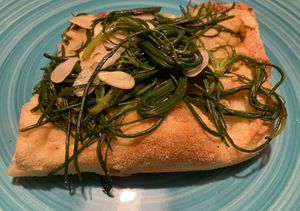 pizza with chickpea hummus, agretti and almonds at Pane e Tempesta in Rome