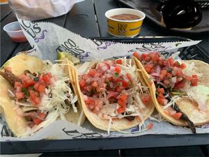 Corn tacos with (from left to right) mushrooms, tofu (ie plant fare), seitan steak. Topped with cabbage and pico de gallo. Bean dip is vegan without cheese. Queso dip blacked out.  at Taco Bus in Clearwater