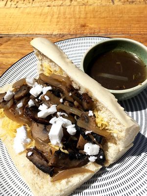French dip mushroom baguette: baguette, sautéed portobellos and onions in thyme broth, vegan cheese, vegan feta, pot of mushroom jus at Meraki Market Cafe in Paphos