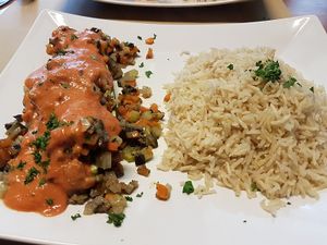 courgette, stuffed with brunoise of eggplant, chestnut mushrooms and other vegetables with tomato-soycream sauce, with rice (17€). at Cafe Manger in Leuven