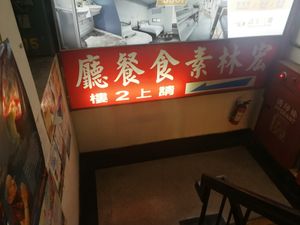 sign pointing the way to the restaurant upstairs at Hóng Lín SùShí LiàoLǐ in Taipei