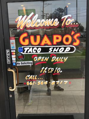 Guapo’s front door with hours at Guapo's Taco Shop in Bakersfield