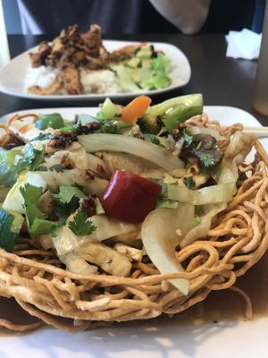 Chow mein and lemongrass seitan rice in the background  at Goji Cafe in Dallas