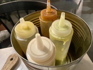 Complimentary sauces: garlic, harissa, tahini and amba  at HUmmUS in The Hague
