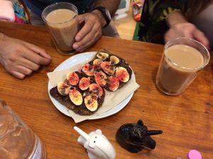 Homemade vegan chocolate cream toast, with banana and seeds, and a coconut chai latte to die for ❤️ at La Tienda de Los Unicornios in Granada