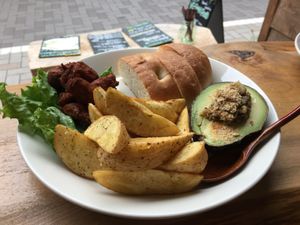 Lunch plate with fried soy meat, potato wedges, avocado stuffed with mushrooms and a side of bread.  at Marugoto Vegan Dining Asakusa in Tokyo
