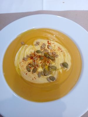 Pumpkin soup as an entree, with cream, pumpkin seeds and spices. Intense flavors. at Giusto Restaurante Vegano in Torrevieja
