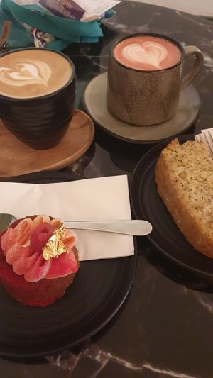 Lemon poppy loaf, rapberry tartlet, latte and beetroot latte at Hampton & Vouis in Manchester