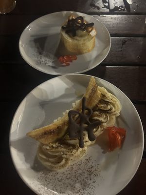 Caramelized banana (bottom) with candied hibiscus flower, chocolate petroglyph, and a haupia whipped cream at Old Lahaina Luau in Lahaina