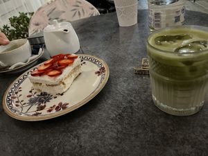 Biscuit and coconut cream cheesecake with strawberries on top, and iced matcha latte with oat milkk  at Copa Cabana in Patmos