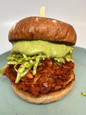 Red Chile Jackruit Sandwich: Jackfruit seasoned with roasted guajillo chiles, topped with our house slaw and green chile pepita sauce. at The Wayside Cafe & Deli in Olympia