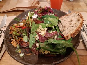 Vegan platter with stir-fry tempeh and peas at Honest Greens - Hortaleza in Madrid