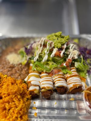 Tacos Dorados / taquitos de Tempeh marinated in a buffalo & chipotle salsa. Served tacos dorados style: topped with chopped lettuce, pico de gallo, guacamole & crema. Rice + Beans at Luna Verde Vegan Mexican Restaurant in Bradley Beach