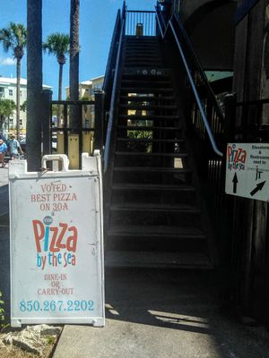 Sign and staircase to go up to the restaurant at Pizza by the Sea in Santa Rosa Beach