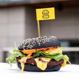 The Hot Chick; Spicy sweet potato & chickpea patty topped w/ rocket, coriander, vegan pepper jack cheese, avocado, smashed nachos, mayo & sriracha sauce. Served on a charcoal bun at V-Face in Dublin