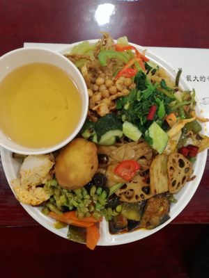 Plate piled hiiiigh, hot mess is this at Qiānhé Qīngxīn 谦和清心素食 - 星辰路 in Chengdu