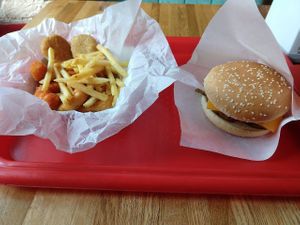 Easy Box and Old School Cheeseburger. An assortment of snacks: fries, nuggets, vegan shrimps, calamari rings, oyster sticks, and burger with seitan patty. at Complex Burger in Moscow