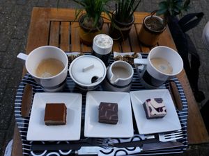 Raw cakes chocolate, berry and tiramisu. Coffee with hazelnut milk and vegan cream at Sweet Vegan in Antwerpen