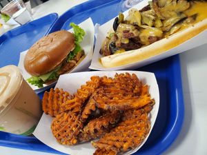 Betterfinger shake, deluxe chicken sandwich, philly cheesesteak, and sweet potato fries at Meta Burger in Denver
