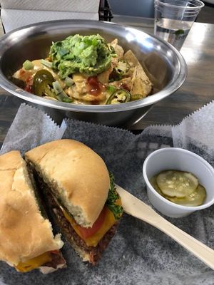 Classic Meta Burger (pickles in the side) and Nachos (added guacamole).  at Meta Burger in Denver