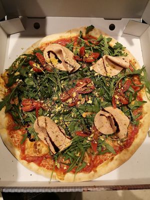 Vegane Pizza mit Pistazien, Mortadella, Tomaten und Rucola. at Veg-Italia in Passau