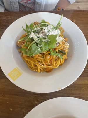 Spaghetti with tomato-based sauce, vegan sausage, and chickpeas. Topped with vegan Parmesan and arugula.  at Pasta Factory in Galway
