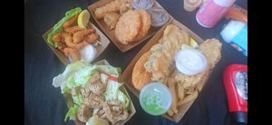 Clockwise : soyveloy, dim sims, potato cakes, Vish and chips, tartare sauce, mushy peas, salt and pepper squid, and breaded scampi prawns. at Northcote Fish & Chips in Northcote