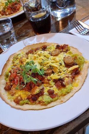 Vegan huevos rancheros (gluten-free tortilla, beans, avocado, salsa, vegan
sausage, vegan grated cheddar with vegan scrambled eggs with chives) at The Bike Shed Motorcycle Club in London