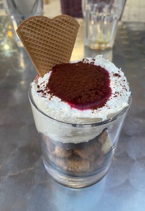 Cremoso de chocolate blanco y coco con base de galletas, helado de avellana y salsa de frutos rojos  at Vegania in Madrid