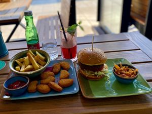 Falafel burger with deep fried carrot shavings and nuggets with seasoned fries. + virgin fruity cocktail 😎 at King's Caffe in Malinska